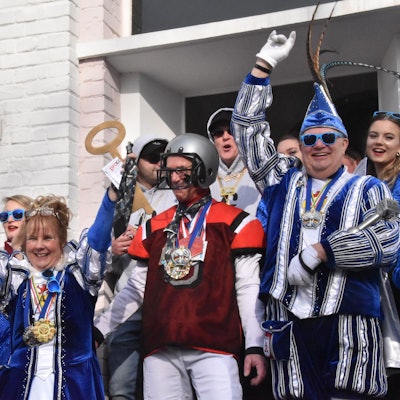 Mehrere Personen in Karnevalskostümen jubeln.