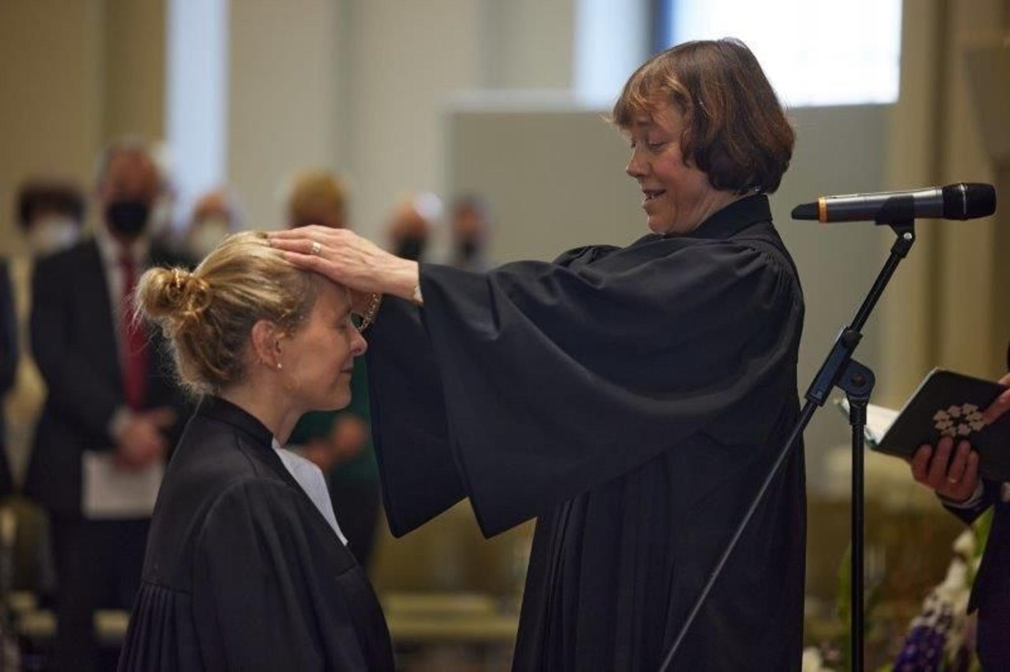 Die EKD-Ratsvorsitzende Annette Kurschus (rechts) legt Prälatin Anne Gidion zu deren Amtseinführung als Bevollmächtigte der EKD zum Segen die Hände auf.