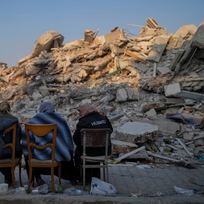 Türkei, Antakya: Frauen sitzen vor den Trümmern bei dem Erdbeben zerstörter Gebäude. Auch rund eineinhalb Wochen nach der Erdbebenkatastrophe mit Zehntausenden Toten erschüttern immer noch weitere Erdstöße die Katastrophenregion.