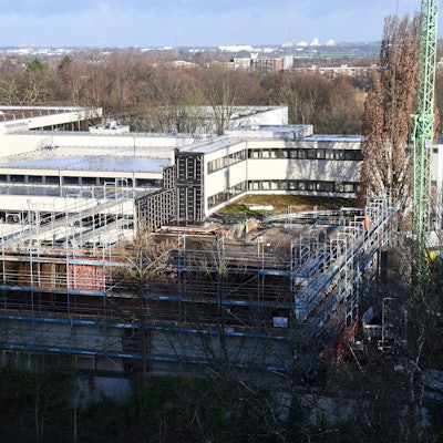 Das Foto zeigt das Ernst-Mach-Gymnasium in Hürth. Es ist wegen Bauarbeiten eingerüstet.
