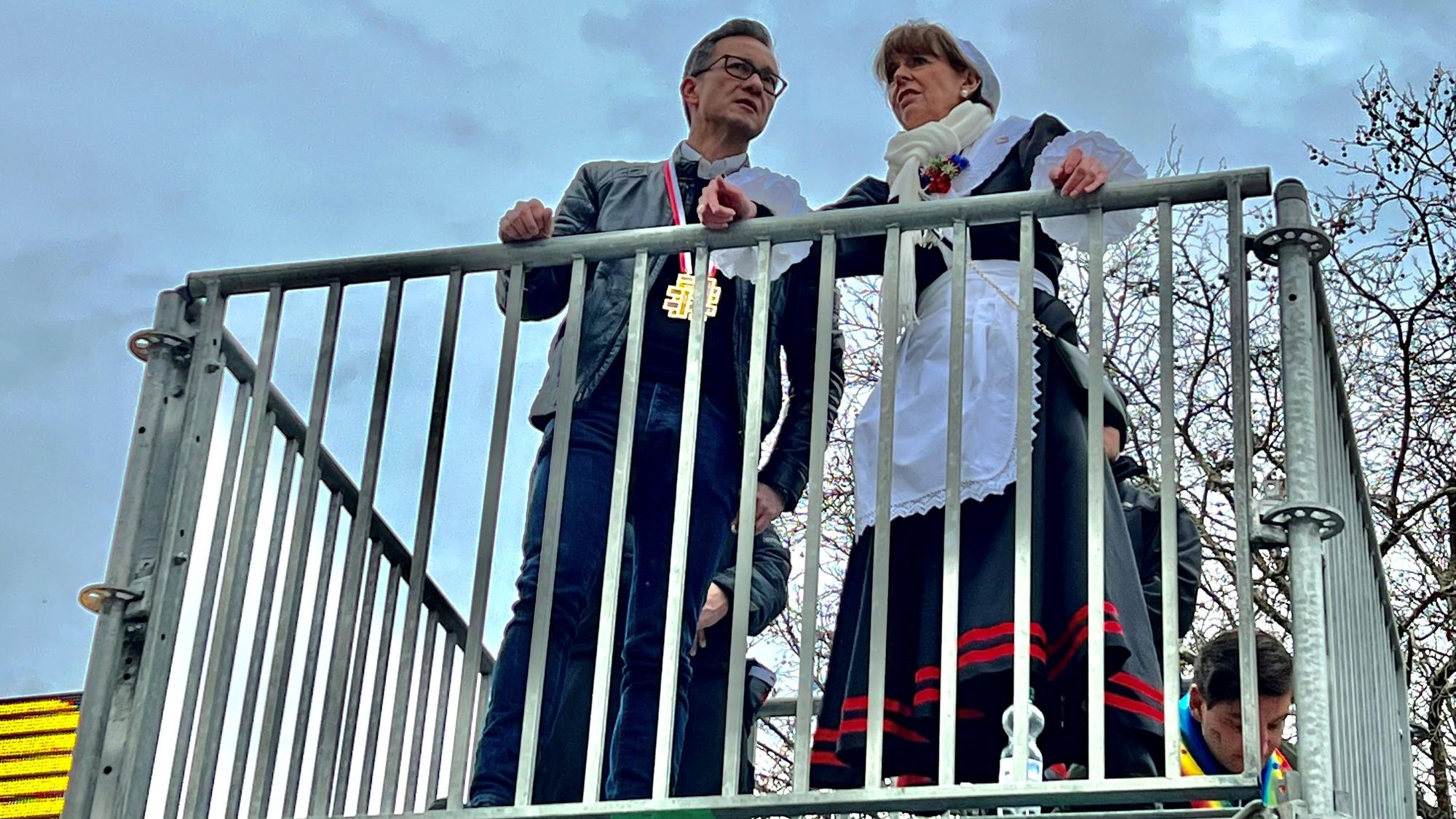 Polizeipräsident Falk Schnabel und Oberbürgermeisterin Henriette Reker stehen auf einer Aussichtsplattform vor der Unimensa und beobachten die Party auf den Uniwiesen.