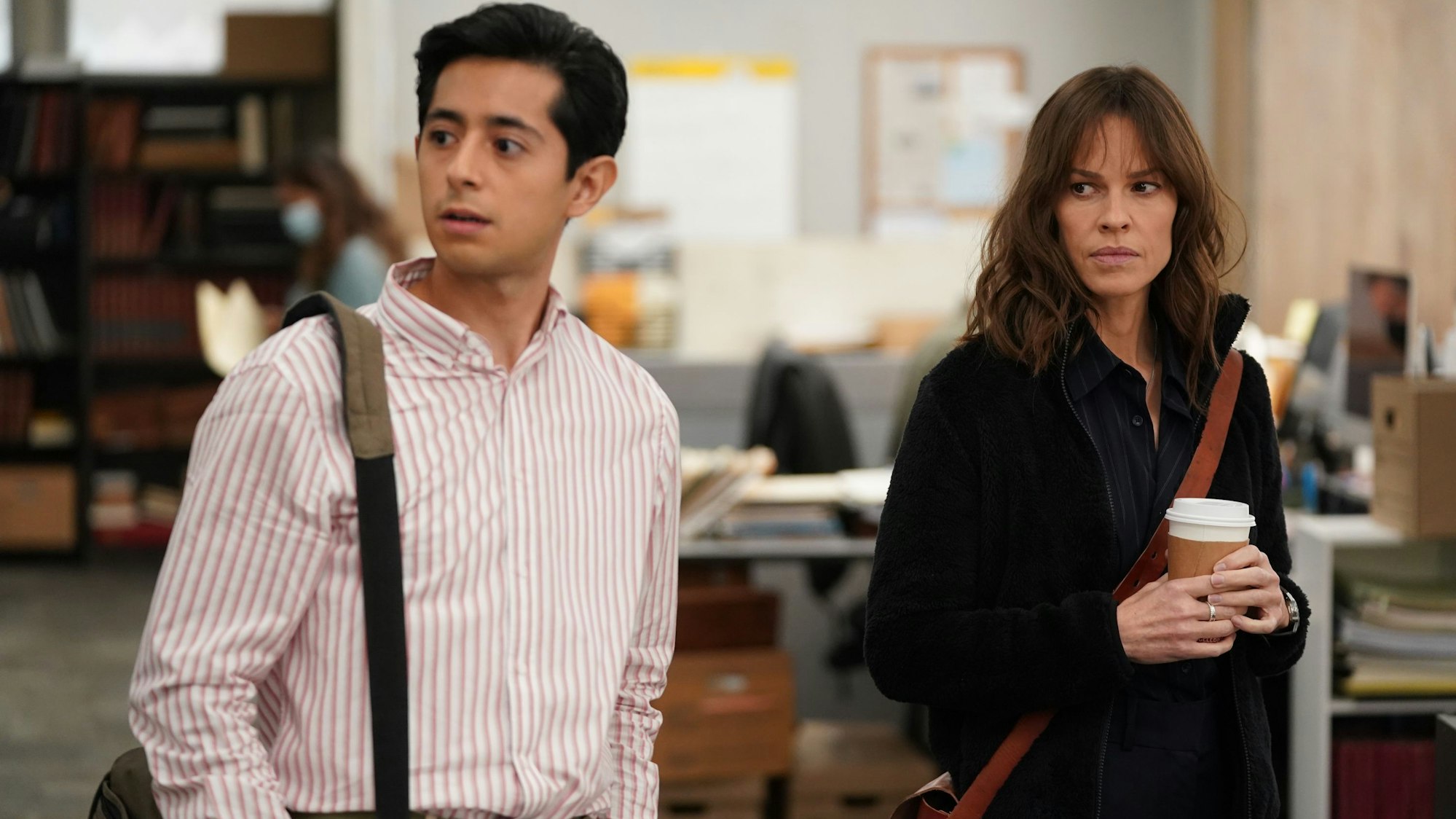 Zwei Journalisten stehen in einem Newsroom.