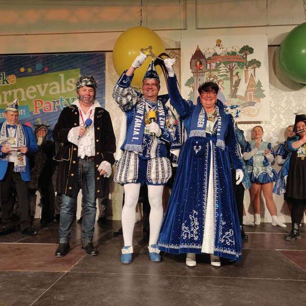 Das Prinzenpaar Mark und Tanja heben den symbolischen Rathausschlüssel hoch, neben ihnen steht auf der Bühne der Wolf kostümierte Bürgermeister Frank Steffes.