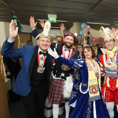 Mehrere Leute sind verkleidet und jubeln in die Kamera.