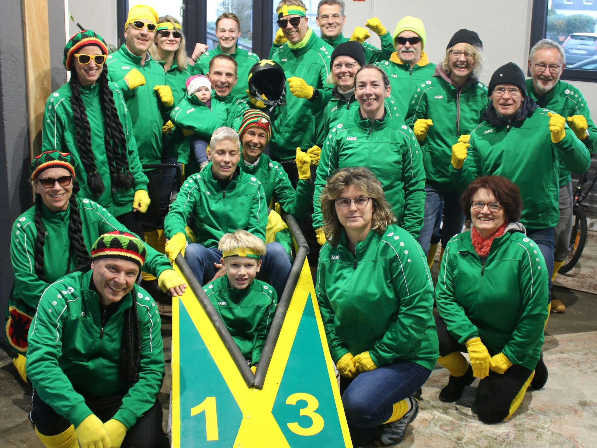 Blick auf eine Gruppe von Frauen, Männern und Kindern um einen Bob.