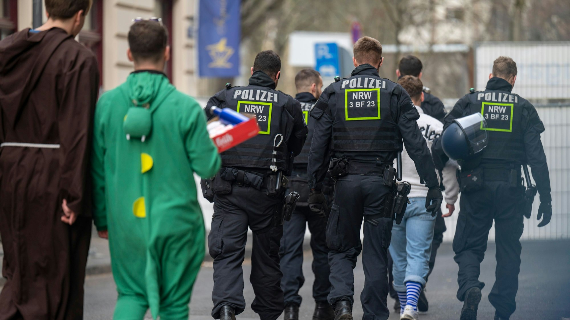 Weiberfastnacht im Kwartier Latäng: Polizisten eskortieren einen Feiernden.