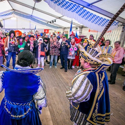 Im Festzelt trat das Prinzenpaar der Narrenzunft auf. Vor dem Prinzenpaar standen Zuschauerinnen und Zuschauer, die verkleidet waren.