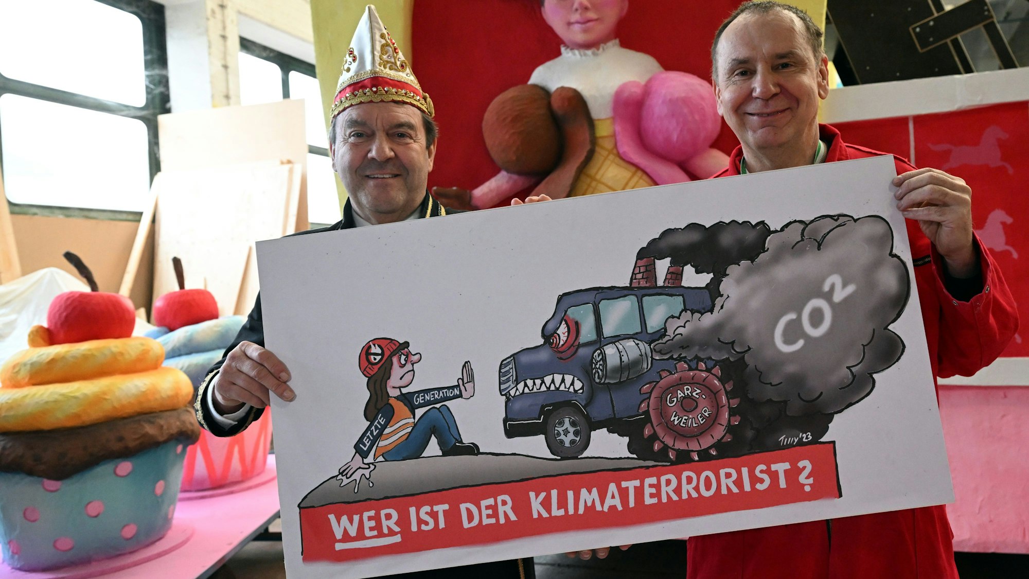 Jacques Tilly (r), Wagenbauer, und Hans-Jürgen Tüllmann, Geschäftsführer des Comitee Düsseldorfer Carneval, präsentieren einen Entwurf für den Mottowagen «Wer ist der Klimaterrorist». Mit der Präsentation des Wagens für den Rosenmontagsumzug will das Comitee Düsseldorfer Carneval unter anderem die Aktivisten der letzten Generation davon abbringen, möglicherweise durch Aktionen den Rosenmontagszug zu stören.