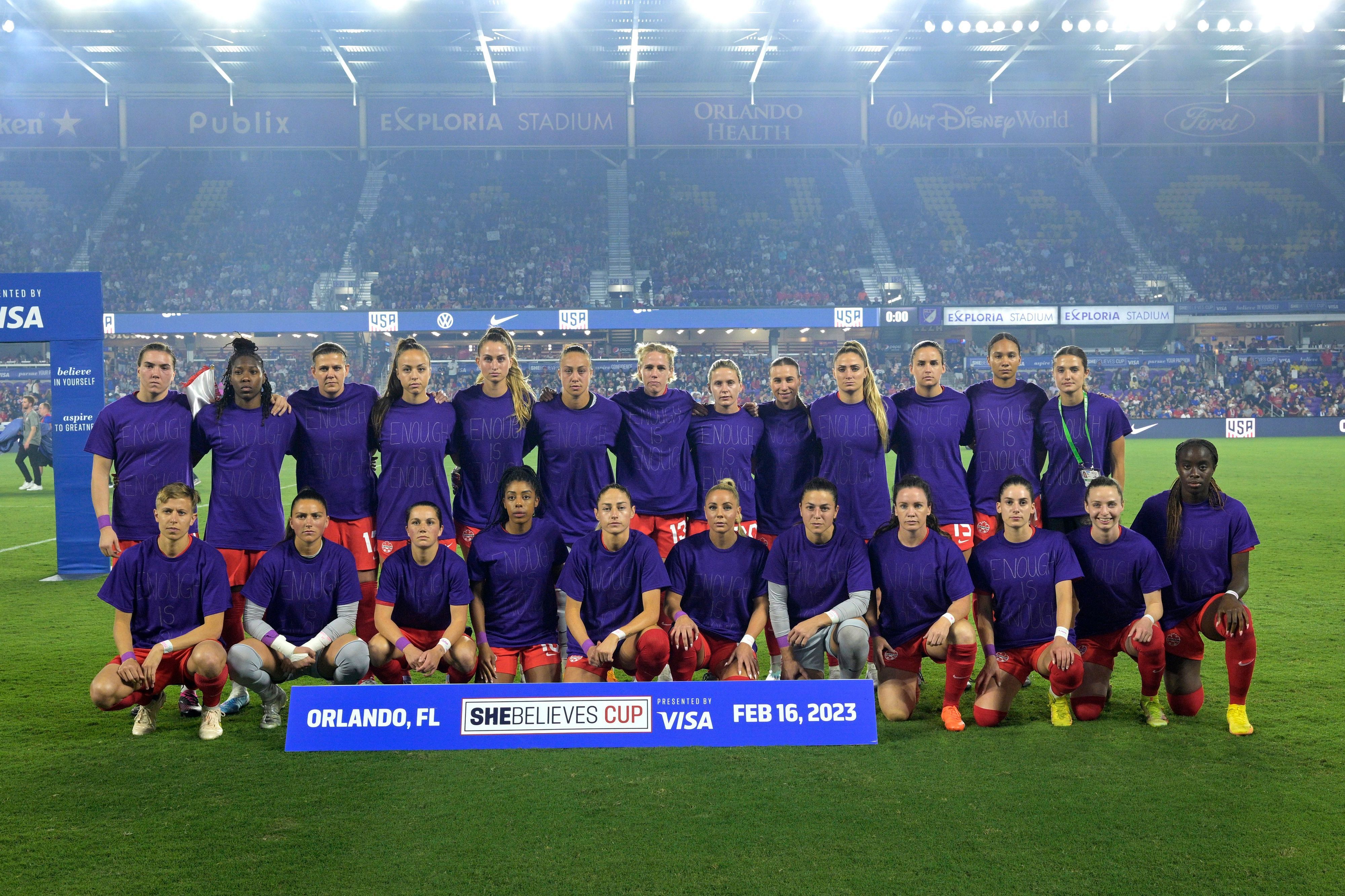 Das kanadische Fußball-Frauennationalteam steht in violetten Shirts aufgereiht hintereinander.