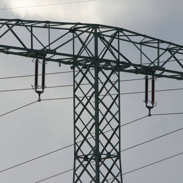 Ein Mann steht auf einem Strommast.