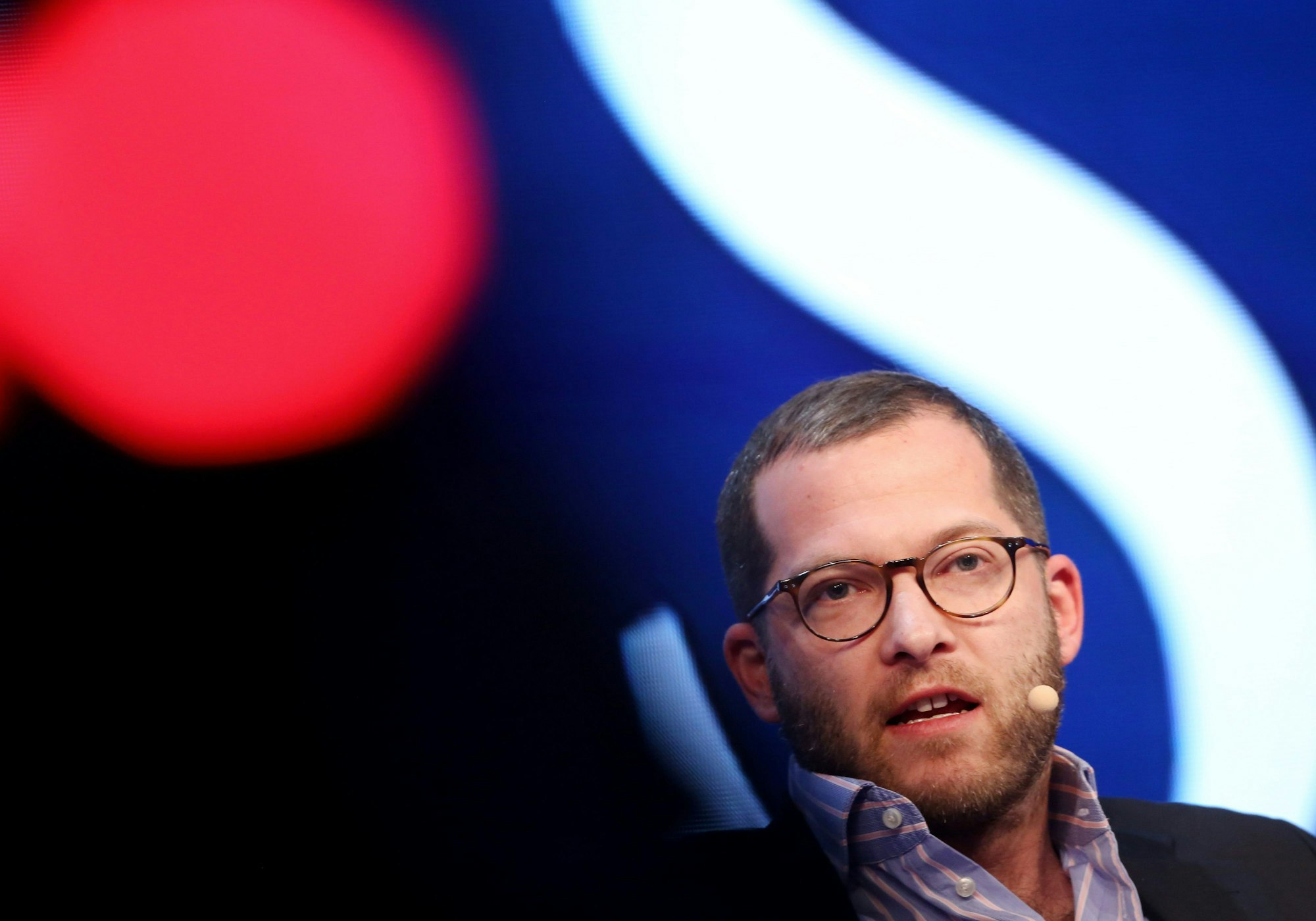 Reichelt trägt eine Brille und spricht in ein Mikrofon, dass an seinem Kopf befestigt ist.