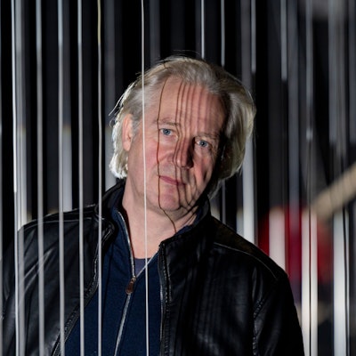 Der Kölner Schauspielintendant Stefan Bachmann schaut im Mülheimer Depot aus den Kulissen seiner Inszenierung von Rainald Goetz' „Johann Holtrop“.