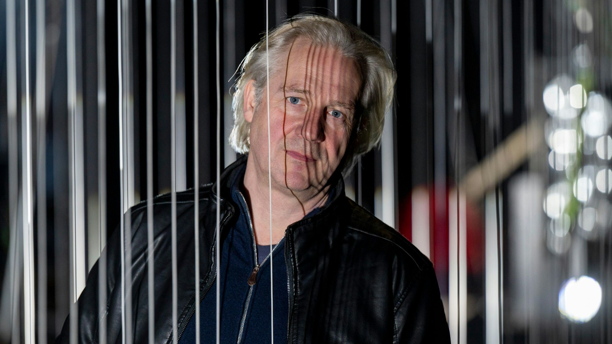 Der Kölner Schauspielintendant Stefan Bachmann schaut im Mülheimer Depot aus den Kulissen seiner Inszenierung von Rainald Goetz' „Johann Holtrop“.