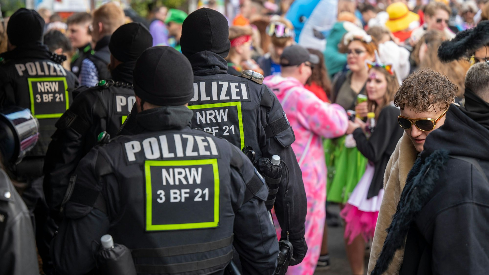 Beamte einer Polizeihundertschaft patrouillieren über die Zülpicher Straße.