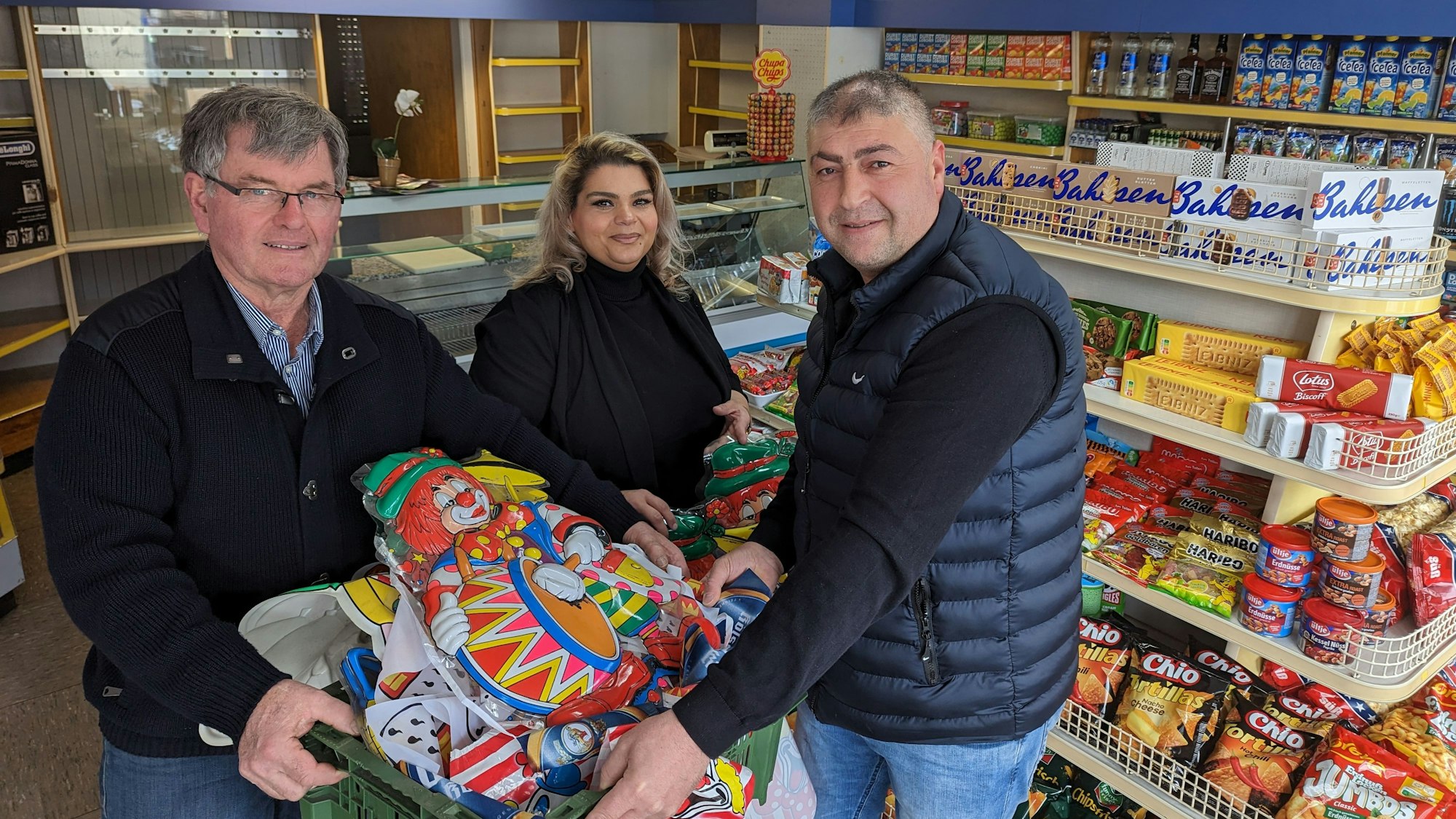 Es sind die Ladenbesitzer mit dem Ortsvorsteher im Kiosk zu sehen.