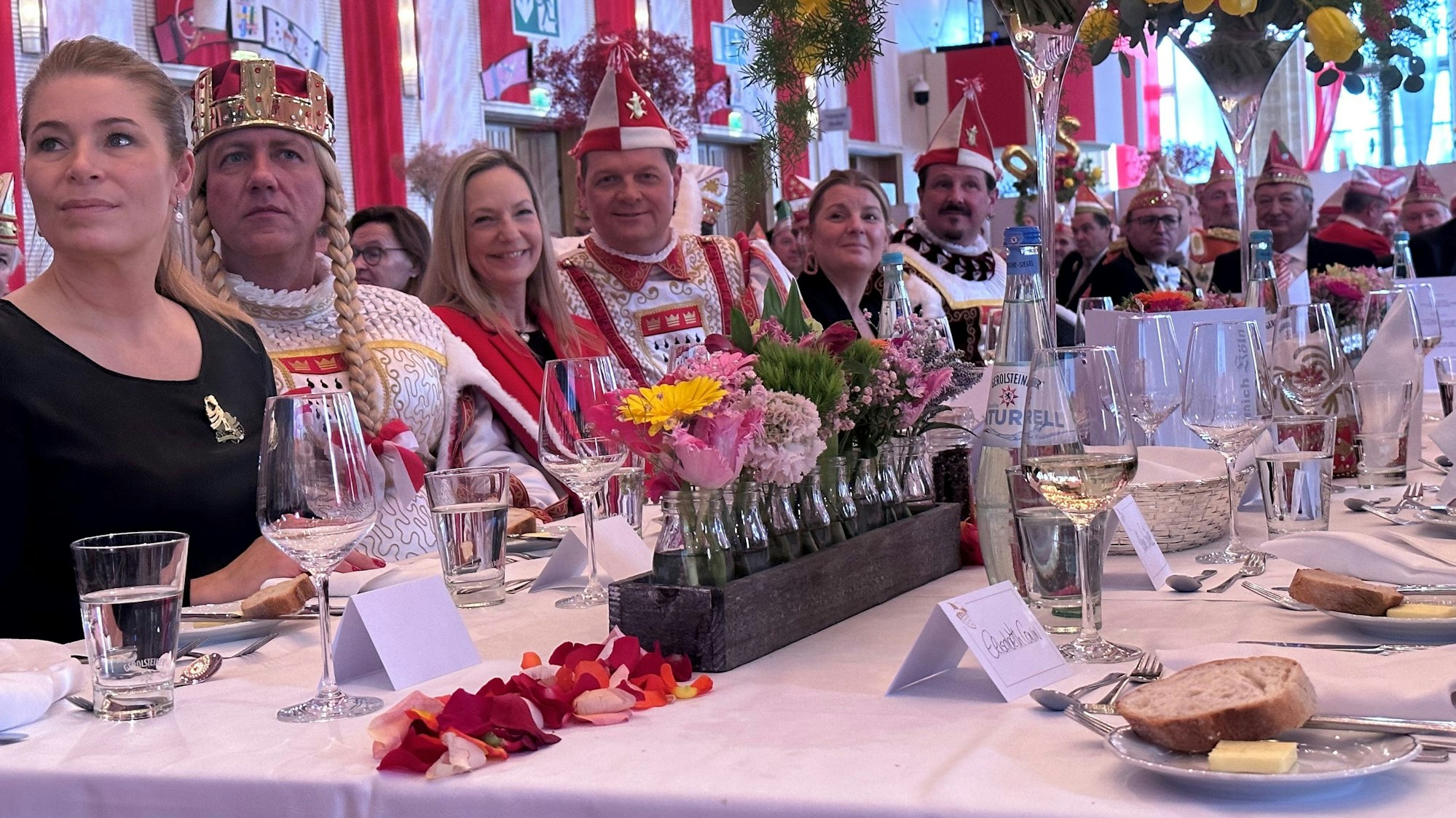 Jecke sitzen an einer langen Tafel.