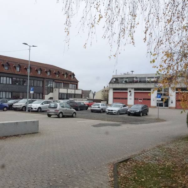 Blick auf den Parkplatz, das Rathaus und die Feuerwehrwache.