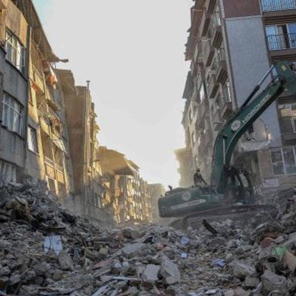 Ein Kran entfernt Schutt von zerstörten Gebäuden im türkischen Hatay