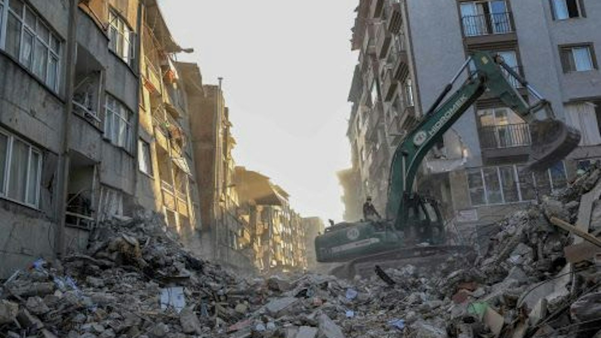Ein Kran entfernt Schutt von zerstörten Gebäuden im türkischen Hatay