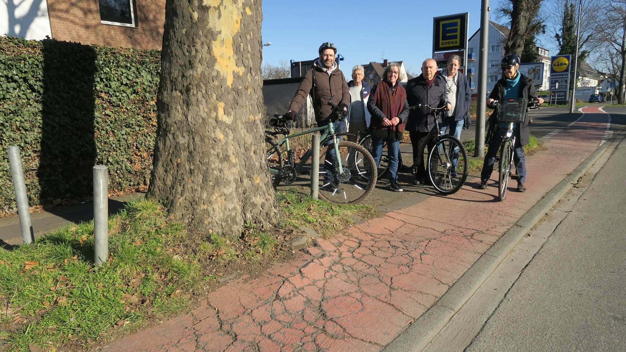 Der Vorstand des CDU-Ortsvereins Merheim steht an der Gefahrenstelle an der Olpener Straße neben einem Baum.