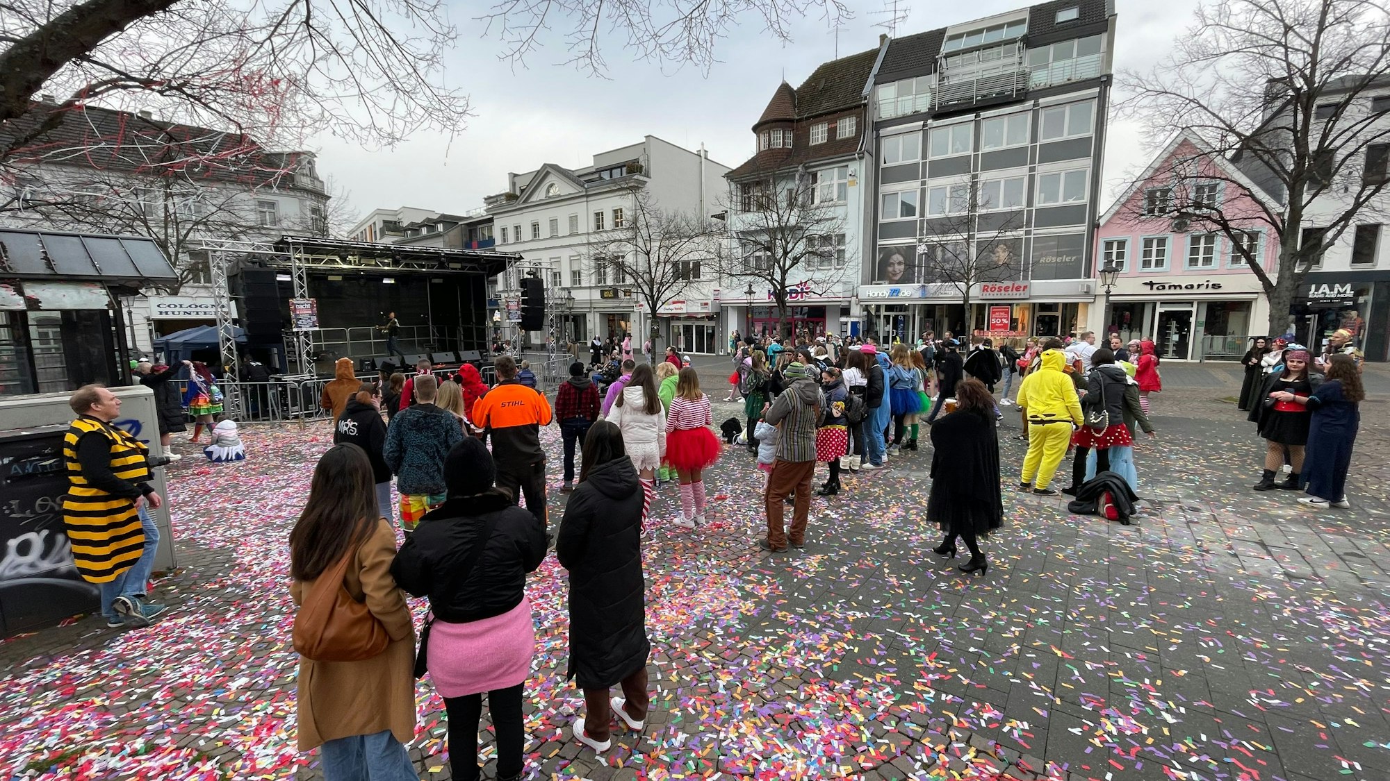 Es ist der Marktplatz zu sehen, auf dem wenige Menschen stehen.