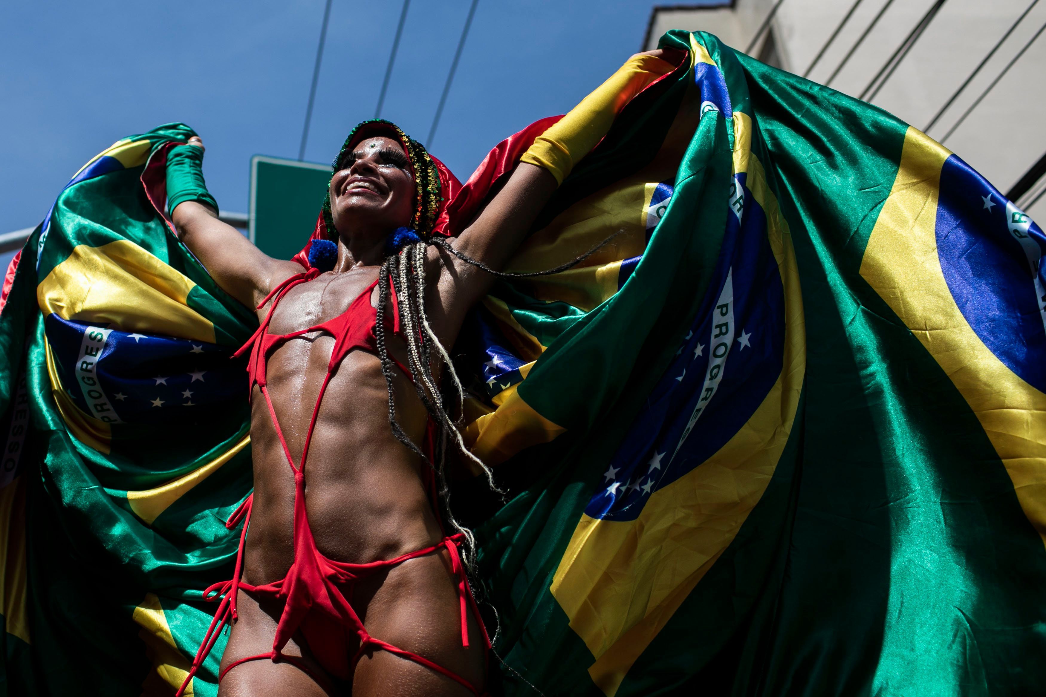 Ein Feiernder steht auf Stelzen umhüllt in einer brasilianischen Flagge während der Carmelitas-Straßenparty am ersten Tag des Karnevals in Rio De Janeiro.