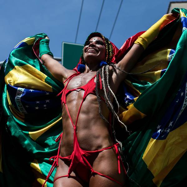 Ein Feiernder steht auf Stelzen umhüllt in einer brasilianischen Flagge während der Carmelitas-Straßenparty am ersten Tag des Karnevals in Rio De Janeiro.