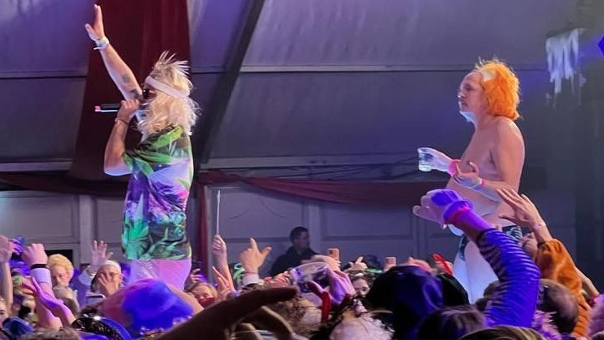 Marteria und DJ stehen vor Publikum auf der Bühne.
