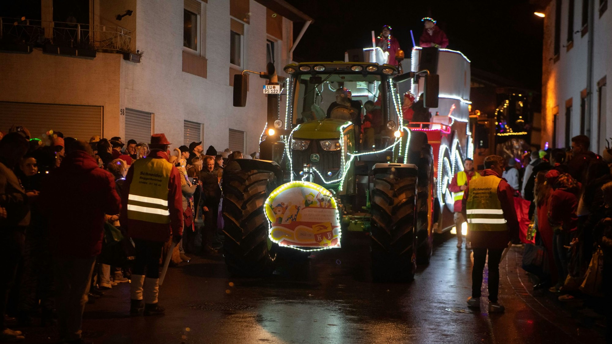 Das Bild zeigt den Lichterzug in Eiserfey. Ein Traktor samt Festwagen bahnt sich seinen Weg durch den Ort.