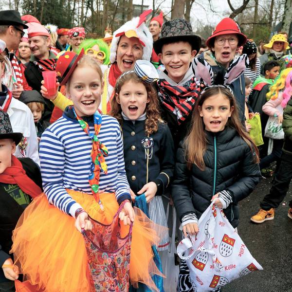 Verkleidete Kinder und Erwachsenen stehen am Zugweg.