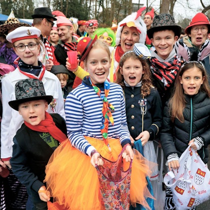 Verkleidete Kinder und Erwachsenen stehen am Zugweg.