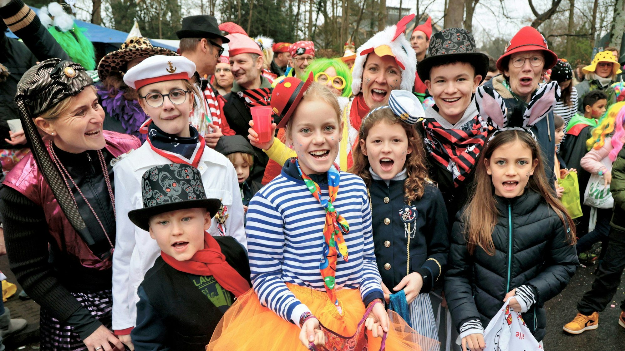 Verkleidete Kinder und Erwachsenen stehen am Zugweg.