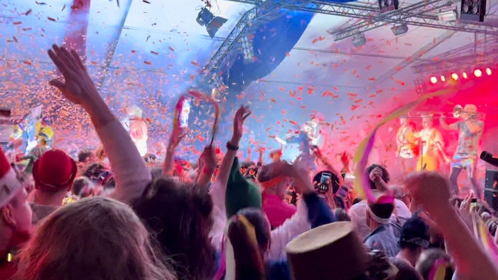 Feiernde Leute stehen im Konfettiregen, im Hintergrund die Musiker.