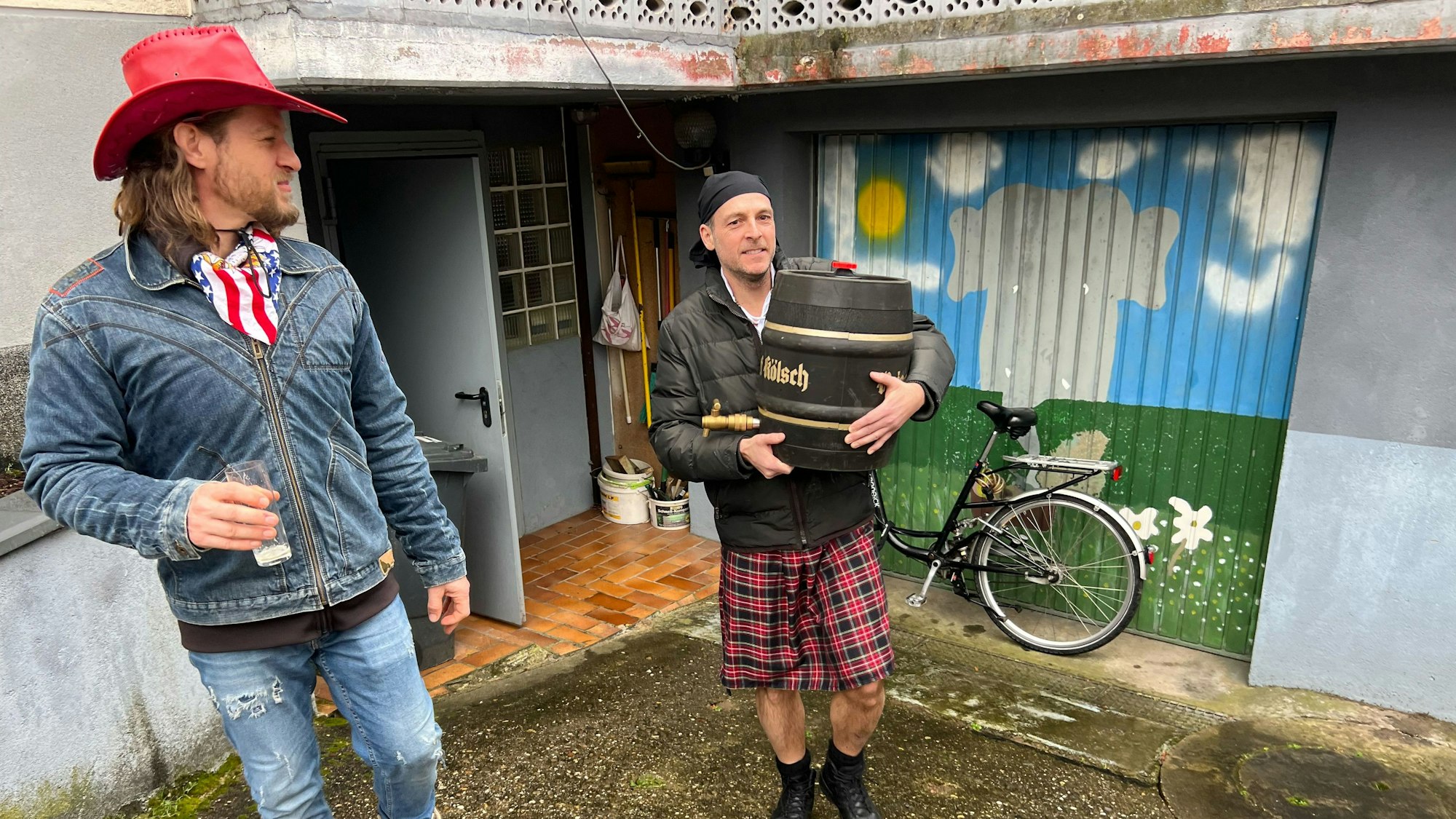 Das Kölschfass muss an die Zugstrecke: Sascha Schmitz trägt es. Jean-Pierre schaut zu.