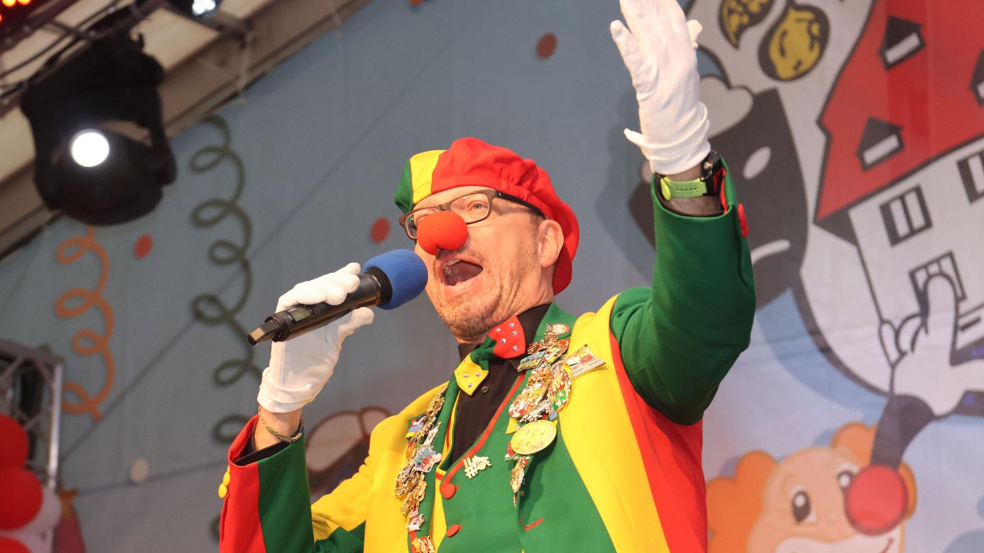 Büttenredner Jörg Runge spricht fröhlich in ein Mikrofon.