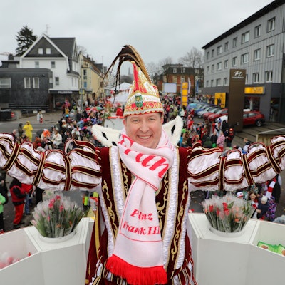 Im Vordergrund der Karnevalsprinz auf seinem Wagen, im Hintergrund die Bensberger.