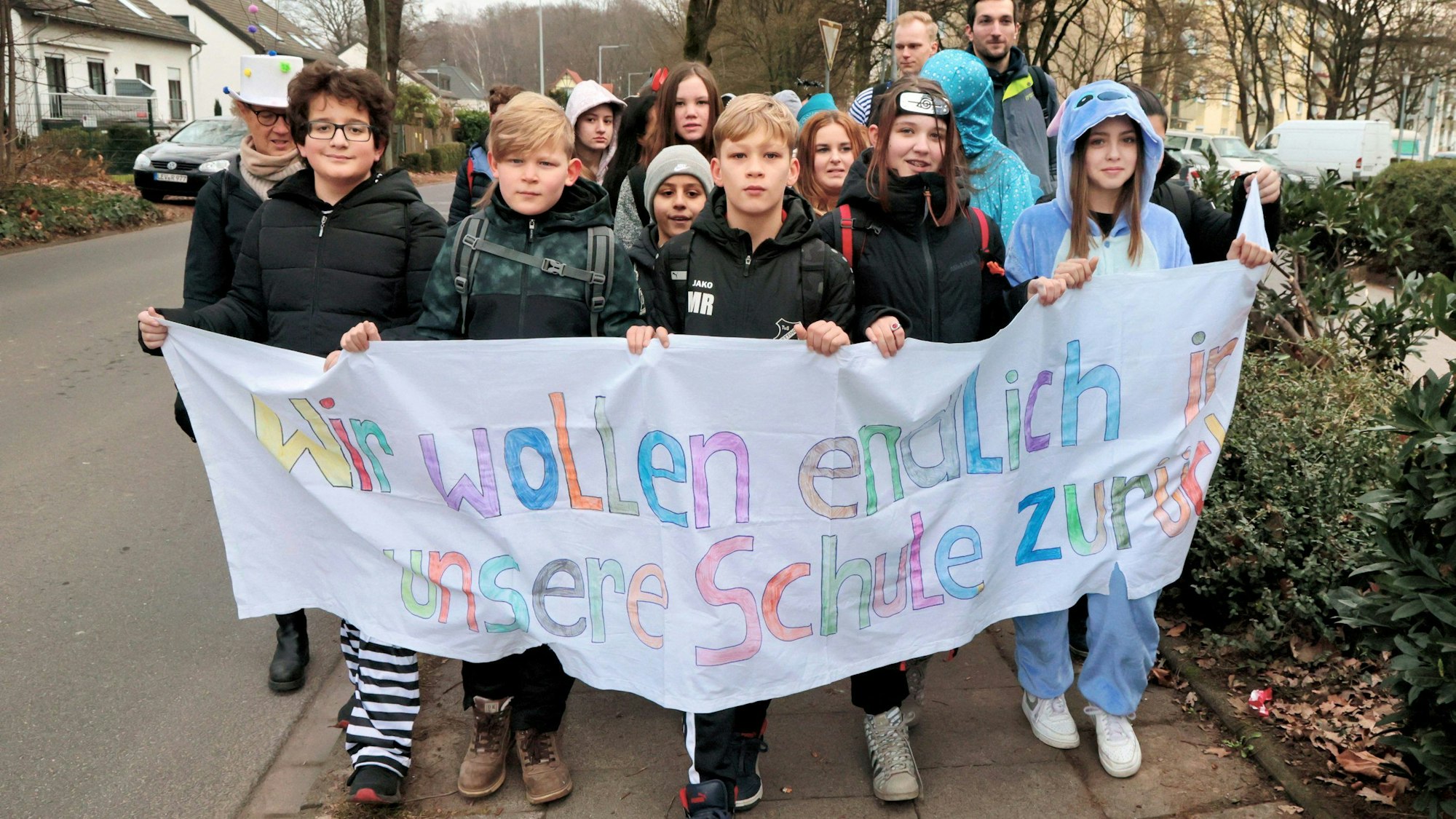 Schüler mit einem Banner: Wir wollen endlich in unsere Schule zurück!