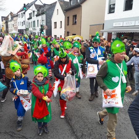 Bunt kostümierte Jecke ziehen durch die Straße.