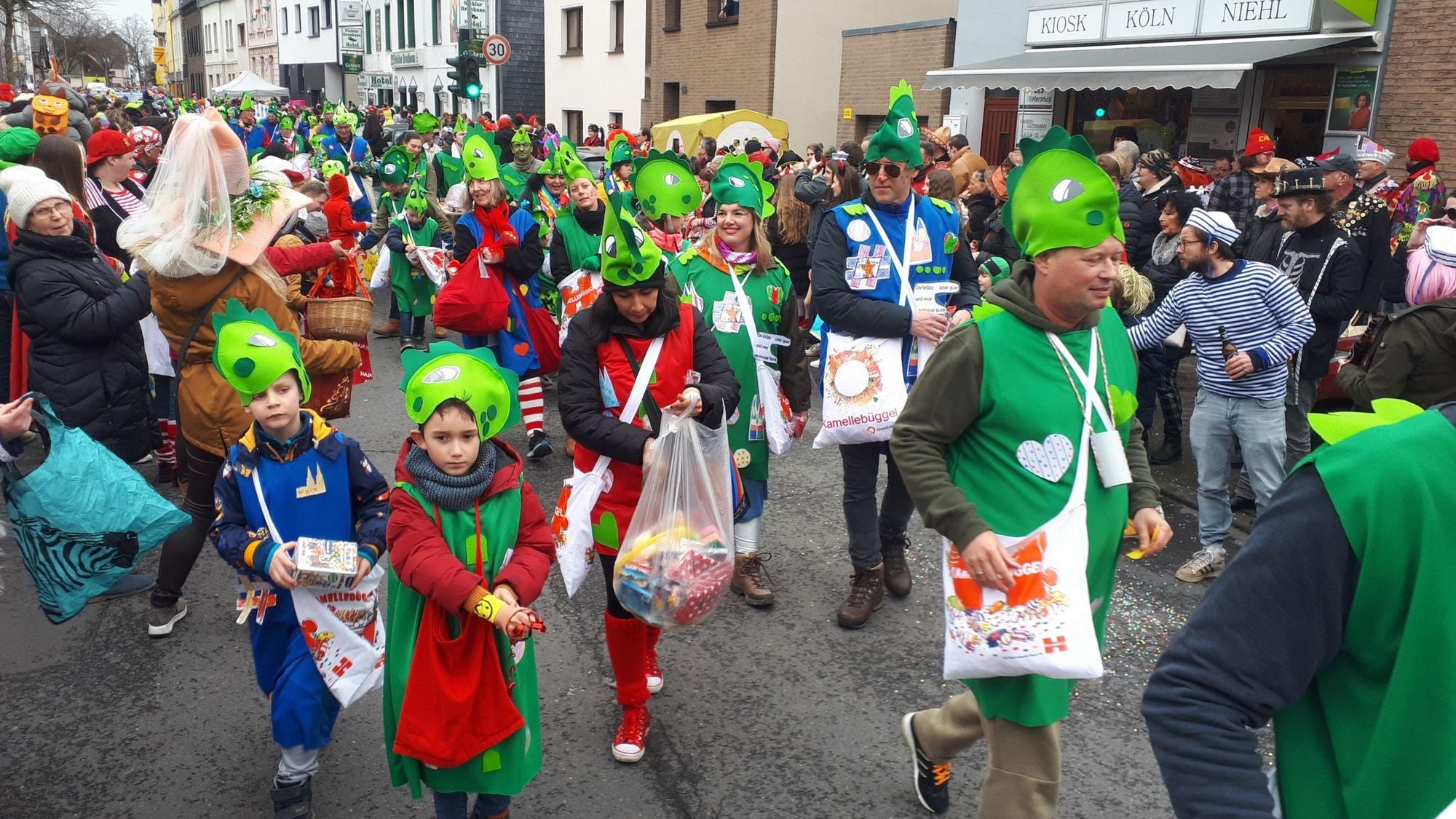 Bunt kostümierte Jecke ziehen durch die Straße.