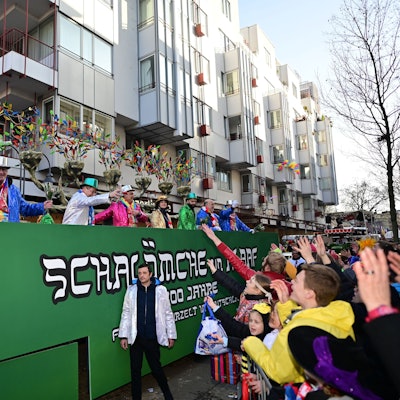 Das Bild zeigt einen Festwagen, der in Grün gehalten ist. Auf der Seite steht „Schalömche un Alaaf“.