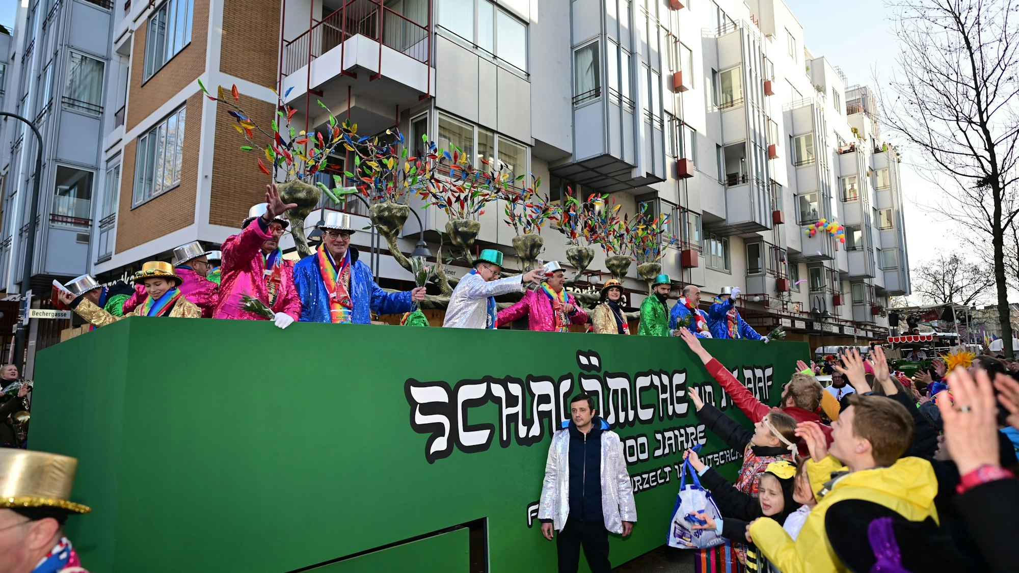 Das Bild zeigt einen Festwagen, der in Grün gehalten ist. Auf der Seite steht „Schalömche un Alaaf“.