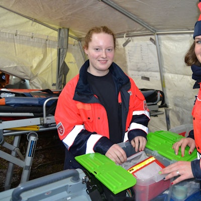 Blick auf zwei Sanitäterinnen, die ihre Ausrüstung prüfen.