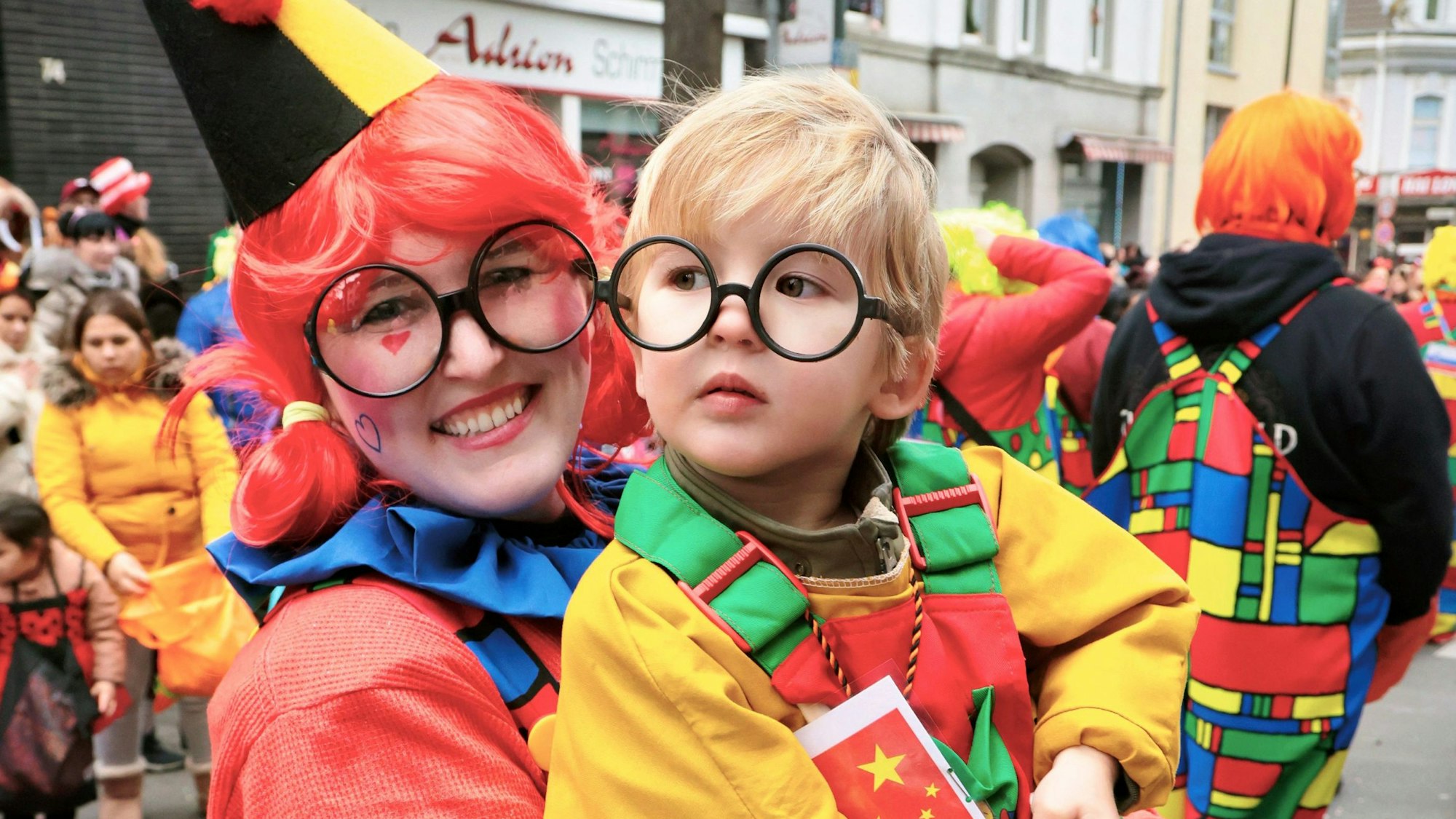 Mutter und Kind in bunten Clownskostümen.