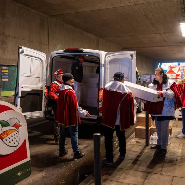 Ehrenamtliche Helfer packen Strüßjer in ein Auto.