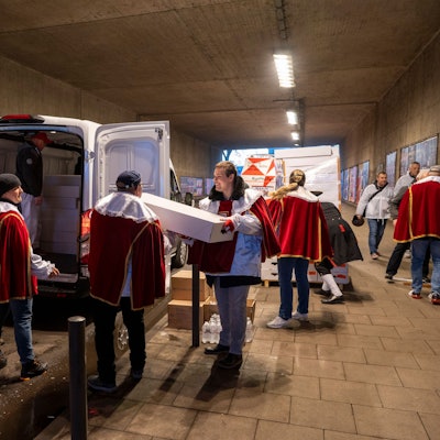 Ehrenamtliche Helfer packen Strüßjer in ein Auto.