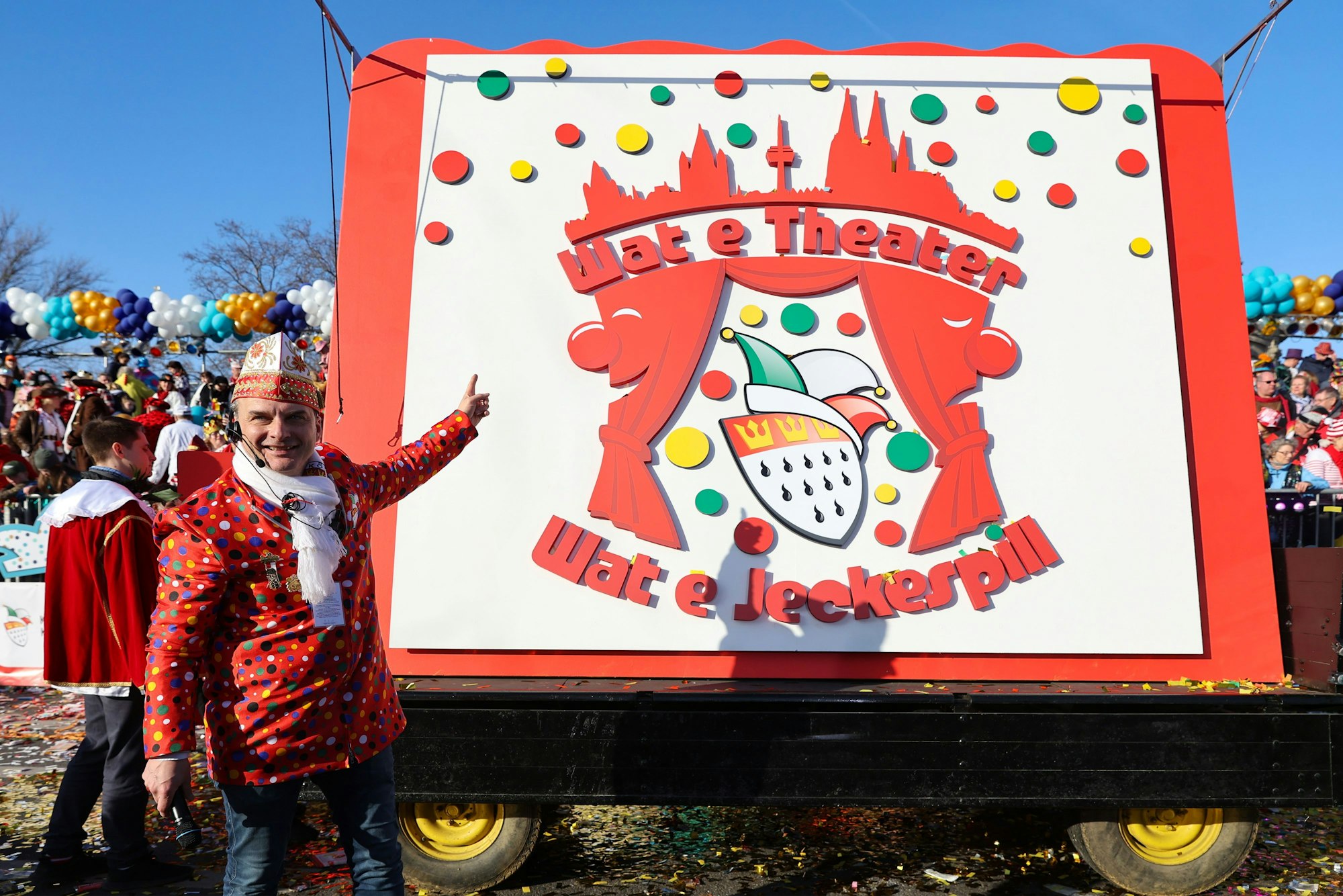 Holger Kirsch steht neben dem Logo und dem Festwagen.