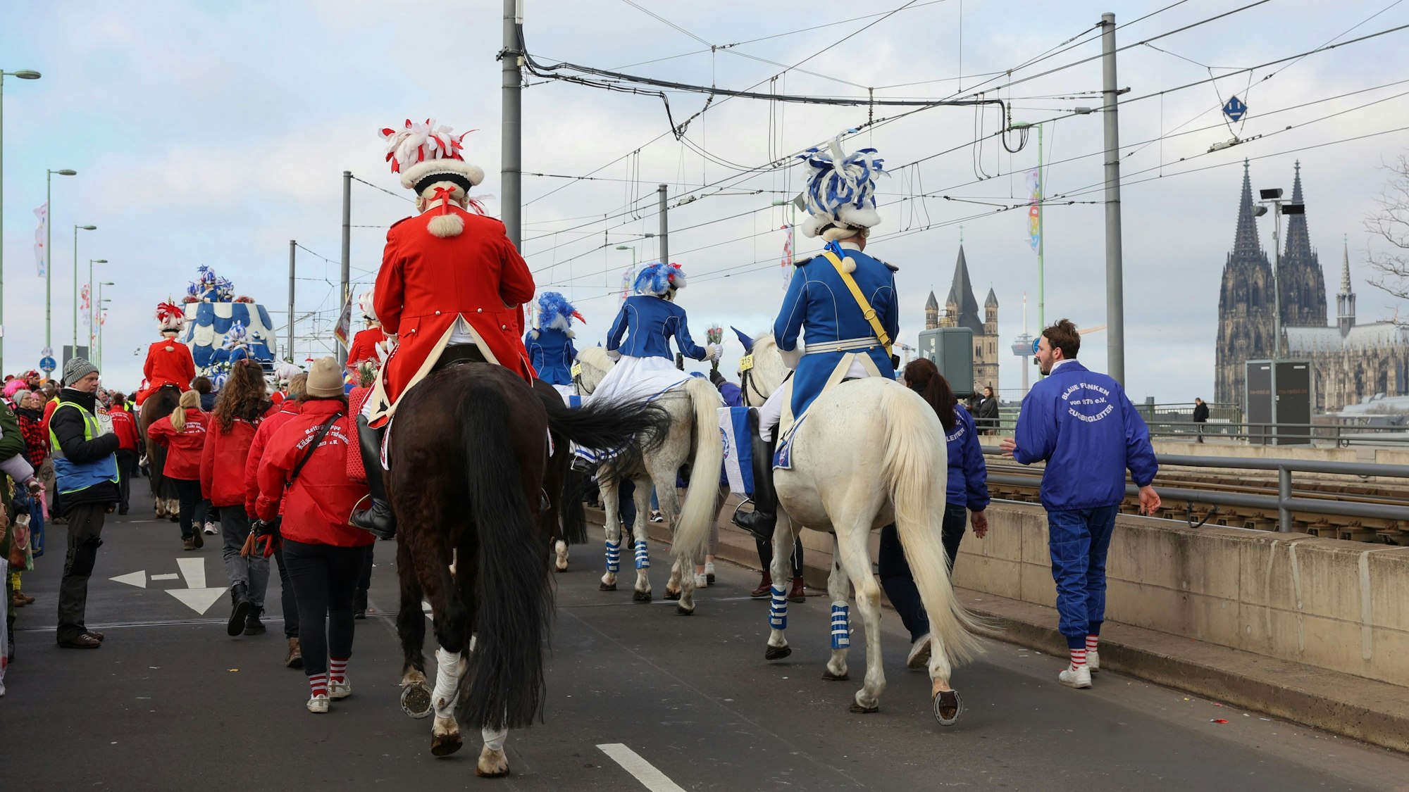 Pferde und Reiter auf der Deutzer Brücke mit dem Dom im Hintergrund.