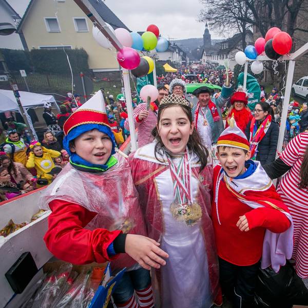 Vier verkleidete Kinder stehen auf einem Karnevalszug.