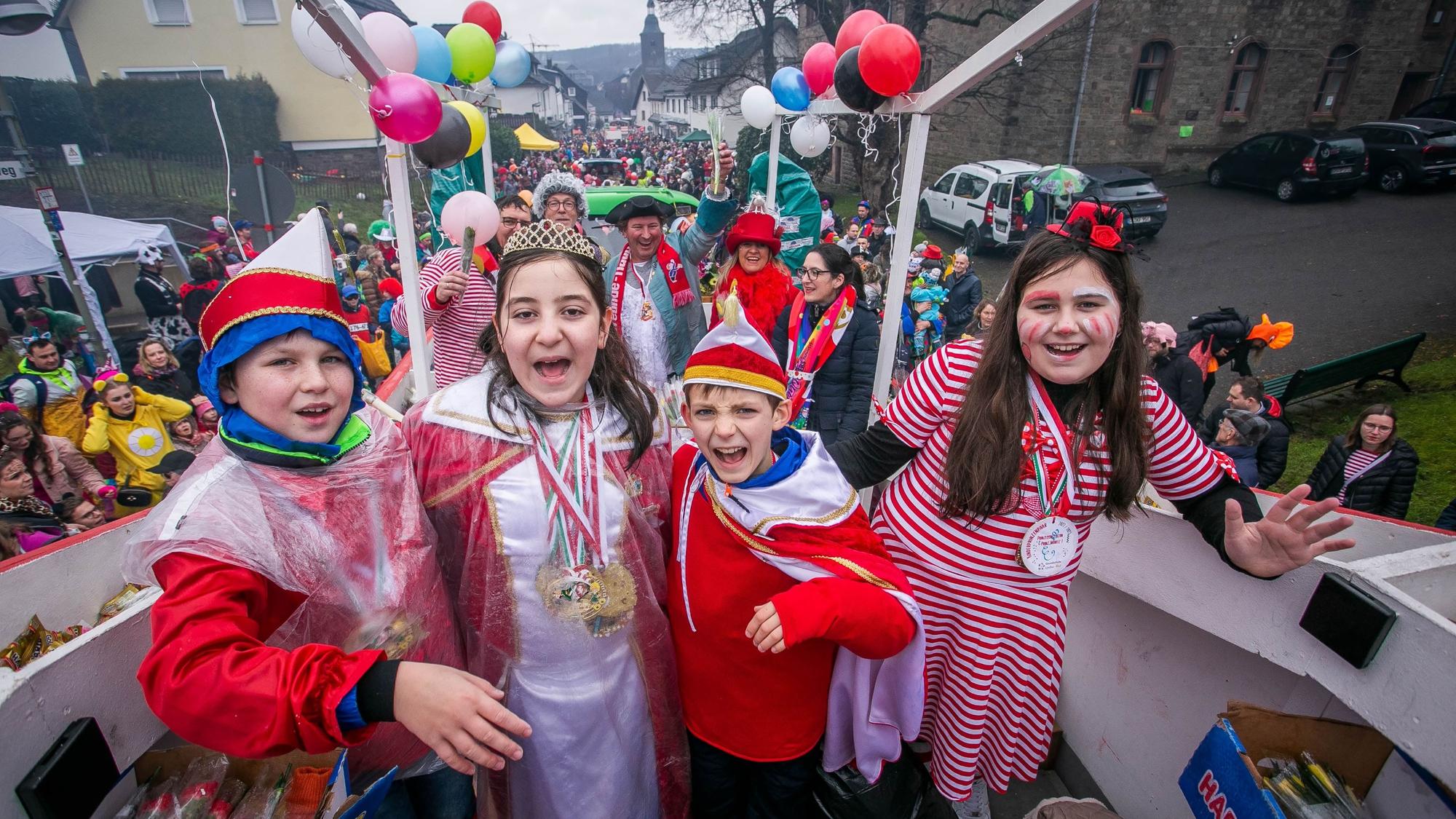 Vier verkleidete Kinder stehen auf einem Karnevalszug.