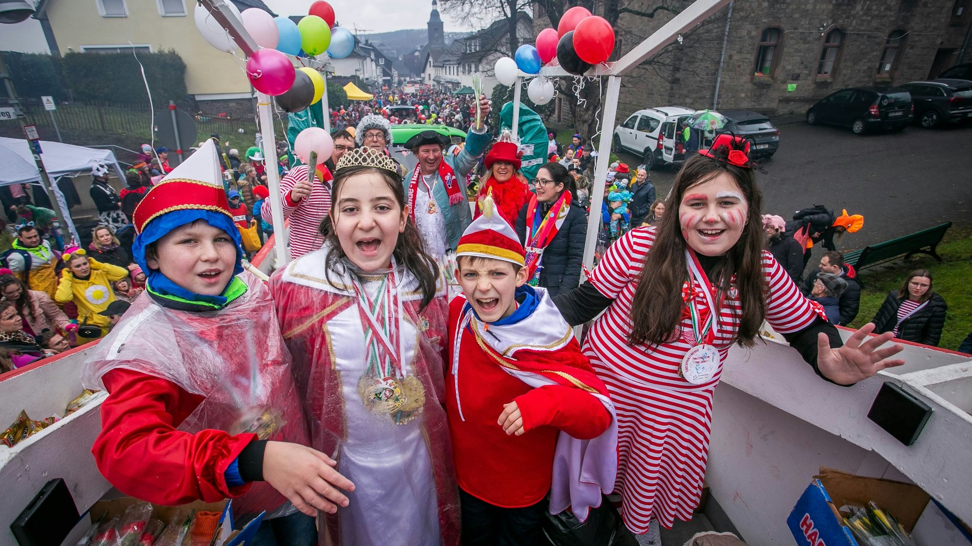 Vier verkleidete Kinder stehen auf einem Karnevalszug.